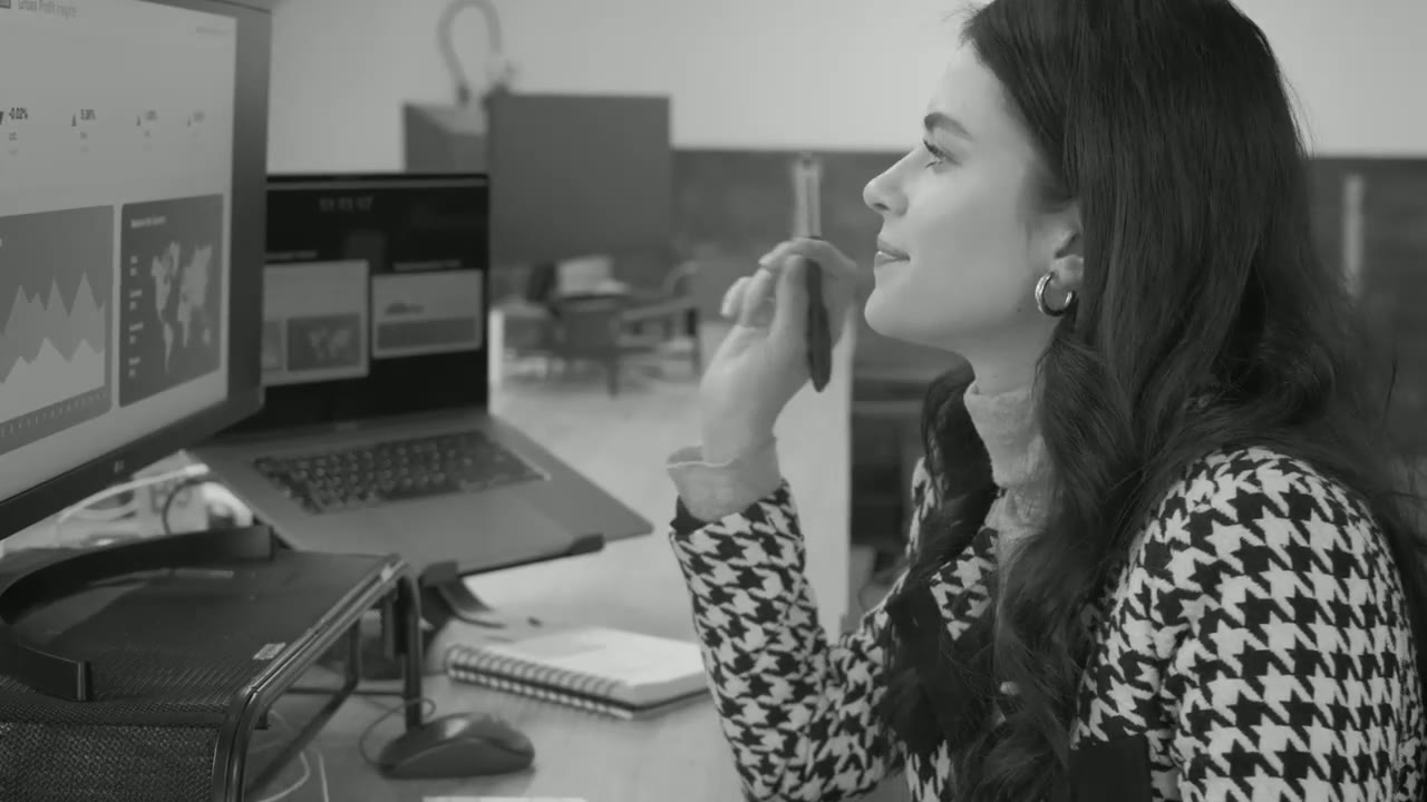 A professional woman reviewing work at her computer